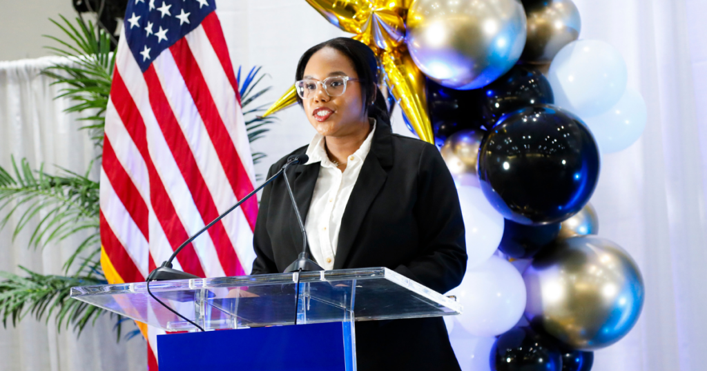 College student Melody stands behind a podium at Miami Dade College.